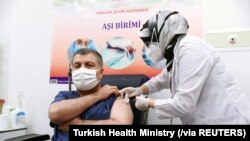 Menteri Kesehatan Turki Fahrettin Koca menerima suntikan dosis pertama CoronaVac, vaksin Covid-19 buatan Sinovac, di Ankara City Hospital, Ankara, Turki, Rabu, 13 Januari 2021. (Foto: Reuters)