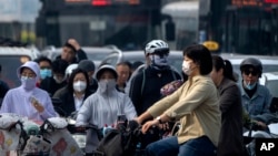 រូបឯកសារ៖ អ្នកធ្វើដំណើរពាក់ម៉ាស​ នៅលើដងផ្លូវមួយ នៅទីក្រុងប៉េកាំង ប្រទេសចិន ក្នុងអំឡុង​ជំងឺរាតត្បាតកូវីដ១៩ កាលពីថ្ងៃទី២៦ ខែឧសភា ឆ្នាំ២០២៣។ 