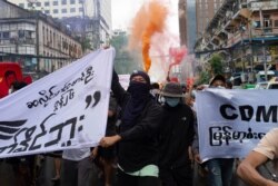 FILE - Anti-coup protesters shout slogans as they march during a protest in Pabedan township against the military junta, in Yangon, Myanmar, June 26, 2021.