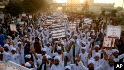 FILE - Pakistani religious students rally for the implementation of a blasphemy law and against the acquittal of Aasia Bibi, in Karachi, Pakistan, Nov. 21, 2018.