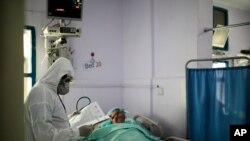 File - A medical worker wearing personal protective equipment takes care of a COVID-19 patient in an intensive care unit at a hospital in Sanaa, Yemen, June 14, 2020. 