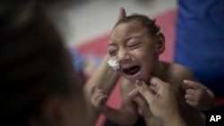 One-year-old Jose Wesley Campos, who was born with microcephaly, cries during a physical therapy session at the AACD rehabilitation center in Recife, Brazil, Sept. 28, 2016.