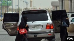 Dua perempuan Saudi keluar dari sebuah mobil di Riyadh (17/6).