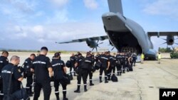 TOPSHOT - This handout photograph taken and released on Sept. 10, 2023 by the Spanish Military Emergency Unit shows members of the UME ready to board an Airbus A400 military plane at the Zaragoza air base.
