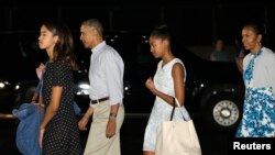 Presiden AS Barack Obama, Ibu Negara Michelle Obama (kanan), Malia (kiri) dan Sasha tiba di Honolulu, Hawaii untuk liburan Natal dan Tahun Baru (19/12).