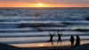 FILE - Teenagers goof off as the sun sets in Encinitas, California, March 31, 2014. 