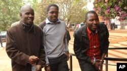Zimbabwean journalists Brian Chitemba, left, Mabasa Sasa, center, and Tinashe Farawo walk in handcuffs, outside the magistrates courts in Harare, Zimbabwe, Nov. 4.2015.