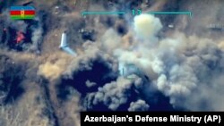 NAGORNO KARABAKH -- In this photo taken from video released by the Azerbaijan's Defense Ministry on Thursday, Oct. 1, 2020, an unmanned aerial vehicle flies over a site where Azerbaijan's forces attack the Armenian army's artillery gun during fighting in 