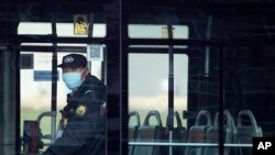 A security guard wearing a mask rides on an empty bus in Beijing, China, Feb. 9, 2020. China's virus death toll have surpassed the number of fatalities in the 2002-2003 SARS epidemic.