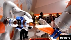 已被中国收购的德国机器人巨头“库卡”公司在汉诺威举行的工业展销会上展示机器人手臂倒一杯德国啤酒。（2017年4月24日） 