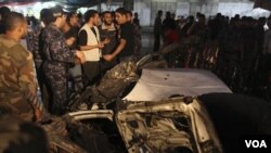 Warga Palestina berkumpul di dekat mobil yang terkena serangan udara Israel di Gaza.