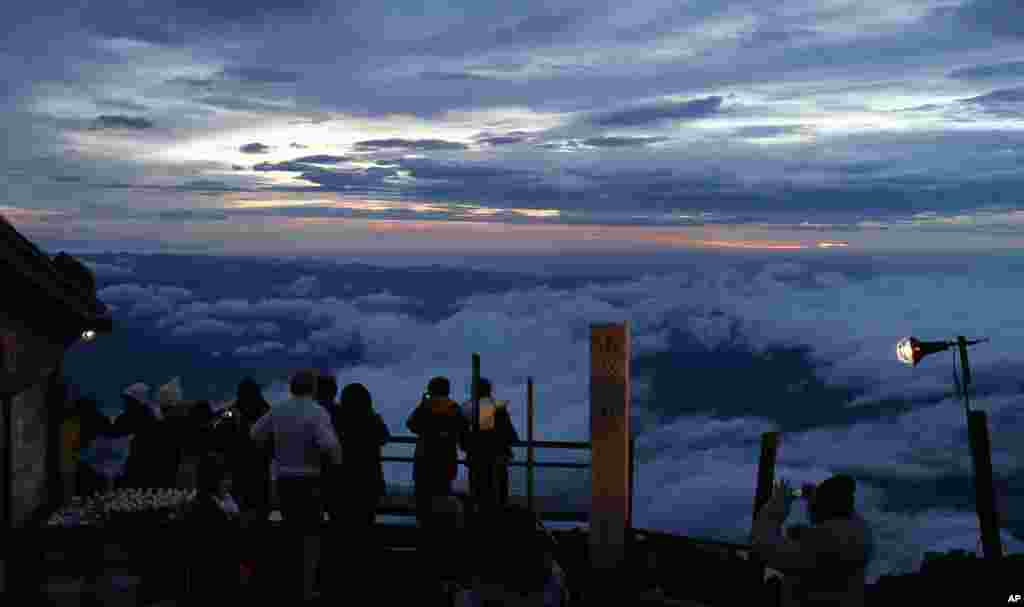 Para pendaki menikmati matahari terbit di Gunung Fuji di kota Fujiyoshida, Yamanashi, Jepang.