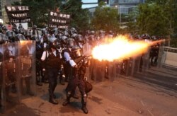 Police officers fire a tear gas during a demonstration against a proposed extradition bill in Hong Kong, June 12, 2019.