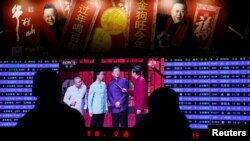 资料照：人们在北京西站观看央视的春晚节目。（2018年1月15日）