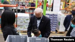 US President Joe Biden hugs a child as he visits the Houston Food Bank in Houston, Texas, Feb. 26, 2021. 