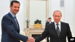 នៅ​ក្នុង​រូបភាព​ដែល​ថត​កាលពី​ថ្ងៃទី២០ ខែតុលា ឆ្នាំ២០១៥​នេះ លោក​ប្រធានាធិបតី​រុស្ស៊ី Vladimir Putin (រូប​ស្តាំ) ចាប់​ដៃ​ជាមួយ​នឹង​លោក​ប្រធានាធិបតី​ស៊ីរី Bashar Assad នៅ​ក្នុង​វិមាន​ Kremlin ក្នុង​ក្រុង​មូស្គូ ប្រទេស​រុស្ស៊ី។