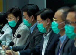Hong Kong Chief Executive Carrie Lam, left, wears a protective face mask speaks during a press conference held in Hong Kong, Jan. 28, 2020.