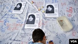 Seorang anak laki-laki ikut menandatangani petisi di London untuk membatalkan hukuman rajam bagi Sakineh Ashtiani. Kasus ini telah menarik banyak simpati dari dunia internasional.