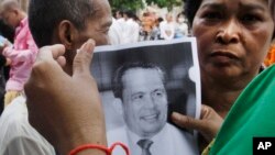Mourners hold a portrait of Cambodian government critic Kem Ley during a funeral ceremony in Phnom Penh, Cambodia, Wednesday, July 13, 2016. 