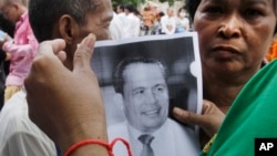 Mourners hold a portrait of Cambodian government critic Kem Ley during a funeral ceremony in Phnom Penh, Cambodia, Wednesday, July 13, 2016. A former Cambodian soldier was charged Wednesday with murder in the killing of Kem in a brazen attack that has raised accusations of a political conspiracy. (AP Photo/Heng Sinith)