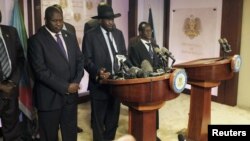 South Sudan President Salva Kiir, center, flanked by former rebel leader Riek Machar, left, and other government officials, addresses a news conference at the Presidential State House in Juba, South Sudan, July 8, 2016. 
