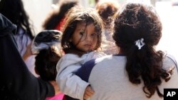 Immigrant families walk to a respite center after they were processed and released by U.S. Customs and Border Protection, June 27, 2018, in McAllen, Texas.