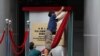 Workers take off a curtain after attend an opening ceremony for China's new Office for Safeguarding National Security in Hong Kong, July 8, 2020.