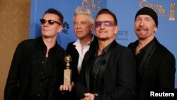 FILE - Adam Clayton (L), Bono (2nd from R), Larry Mullen, Jr. and The Edge (R) from the band U2 pose backstage with their award for Best Original Song, Jan. 12, 2014.