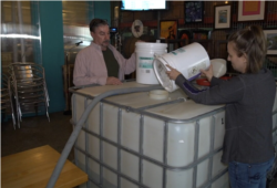 Falls Church Distillers founder Michael Paluzzi (left) with employee Kallie Stavros, making hand sanitizer rather than their usual alcoholic drink products.