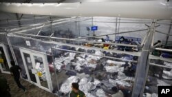 FILE - March 30, 2021 photo, young minors lie inside a pod at the Donna Department of Homeland Security holding facility, main detention center for unaccompanied children in the Rio Grande Valley run by U.S. Customs and Border Protection, Donna, Texas.