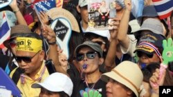 Anti-government protesters, one holds a picture of Thai King Bhumibol Adulyadej, chant slogans during a demonstration against an amnesty bill in Bangkok, Thailand, Nov. 11, 2013. 