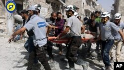 Sept. 21, 2016, file photo, provided by the Syrian Civil Defense White Helmets, rescue workers work the site of airstrikes in the al-Sakhour neighborhood of the rebel-held part of eastern Aleppo, Syria.