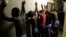 Men stand against a wall as police officers search their room during a raid at an Alexandra township hostel considered a hot spot for anti-immigrant attacks in Johannesburg, South Africa, April 23, 2015.