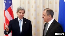 Menteri Luar Negeri AS John Kerry (kiri) berbicara pada Menteri Luar Negeri Rusia Sergei Lavrov sebelum bertemu di Moskow, Rusia, 15 Desember 2015. 