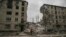 A man rides his bicycle in front of a destroyed apartment building after a Russian strike in the city of Avdiivka, Donetsk Oblast, on March 18, 2023.