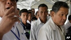 លោក ភី ភួន (ស្តាំ) ​អតីត​កង​ការពារ​​របស់​ ប៉ុល ពត​ ជា​ជនជាតិ​ចារ៉ាយ និង​ជា​អតីត​អ្នក​នាំ​សារ​របស់​ អៀង សារី អតីត​រដ្ឋមន្ត្រី​ការ​បរទេស​​ខ្មែរ​ក្រហម តម្រង់​ជួរ​នៅ​ច្រក​ចូល​សាលាក្តី​ខ្មែរ​ក្រហម​នៅ​ជាយ​ក្រុង​ភ្នំពេញ​កាល​ពី​ថ្ងៃ​ទី​២១ ខែ​វិច្ឆិកា ឆ្នាំ​២០១១។