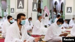 Jemaah haji mengenakan masker dan menjaga jarak sosial saat berdoa di dalam Masjid Namira di Arafat, menandai hari terpenting dalam ibadah Haji, Hari Arafat, di tengah pandemi Covid-19, 30 Juli 2020. 