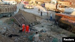 Lebanese army soldiers, civil defense members and rescuers are seen at the site of a fuel tank explosion, in Akkar, northern Lebanon, Aug. 15, 2021.