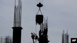 Indian laborers work at a construction site in Mumbai, India, June 4, 2012