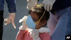 지난 27일 페루 리마의 버스역에서 소녀가 신종 코로나바이러스 감염증(COVID-19)를 막기 위해 마스크를 착용하고 있다.