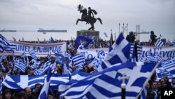 Para pengunjuk rasa mengibarkan bendera dan poster dalam demonstrasi menentang penggunaan kata "Macedonia" untuk nama negara tetangga di sebelah utara, di Kota Thessaloniki, Minggu, 21 Januari 2018. 