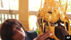 ព្រះអង្គ​ម្ចាស់​ក្សត្រិយ៍​នរោត្តម​ បុប្ផា​ទេវី ជួយ​តម្រង់​ម្កុដ​របស់​អ្នក​រាំ​របាំ​អប្សរា​ម្នាក់។