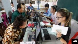 Locals sit for registering their names during a voter registration process of the National Election Committee (NEC) in Phnom Penh, Cambodia, Thursday, Sept. 1, 2016. 