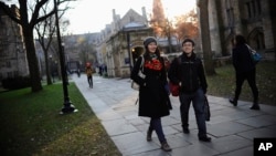 FILE - Yale University sophomore Yupei Guo, left, walks with friend Joseph Lachman on the school's campus in New Haven, Conn., In Nov. 20, 2014. With more undergraduates coming from overseas than ever, some Ivy League universities are reaching out in new ways to attract international students of more varied backgrounds -- and particularly from China, which sends more students to the U.S. than any other country.