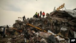 7일 터키 피해 지역인 말라티아의 무너진 건물 잔해에서 구조대원들이 생존자를 찾고 있다.