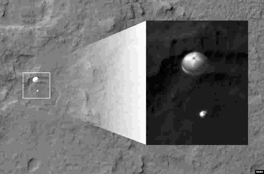 NASA's Curiosity rover and its parachute, left, descend to the Martian surface on August 5, 2012. The inset image is a cutout of the rover stretched to avoid saturation. The rover is descending toward the etched plains just north of the sand dunes.