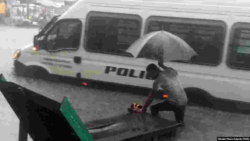 Reconnaître le passage à piétons devient difficile pour cet homme obligé de marcher dans l’eau qui lui arrive au genou, aux côtés des véhicules, dans un des quartiers inondés, à Cotonou, Benin, 8 octobre 2016. VOA/Ginette Fleure Adande