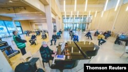 A pianist entertains elderly residents as they wait to receive a coronavirus disease (COVID-19) vaccine at the Rotnes church, in Nittedal, Norway Jan. 21, 2021.