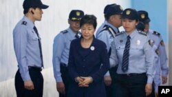 Former South Korean President Park Geun-hye, center, arrives for a court hearing in Seoul, South Korea, May 23, 2017. North Korea on Wednesday vowed to execute Park and her spy director, accusing them of planning to assassinate its supreme leadership.