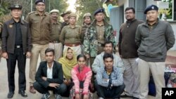 Members of a Muslim Rohingya family sit as they pose for a photograph with Indian and Myanmar security officials before their deportation on India-Myanmar border at Moreh in the northeastern state of Manipur, India, Jan. 3, 2019. 